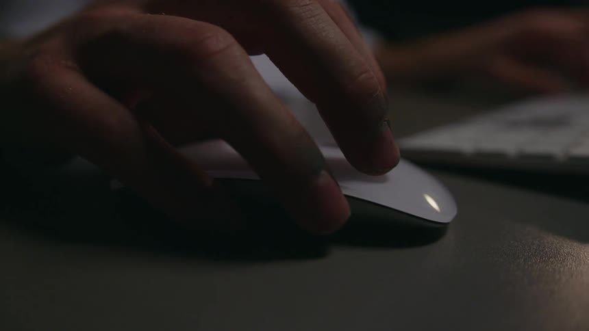 Person manipulates computer mouse while using keyboard