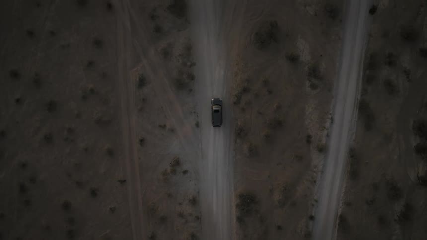Dark vehicle drives down rural road