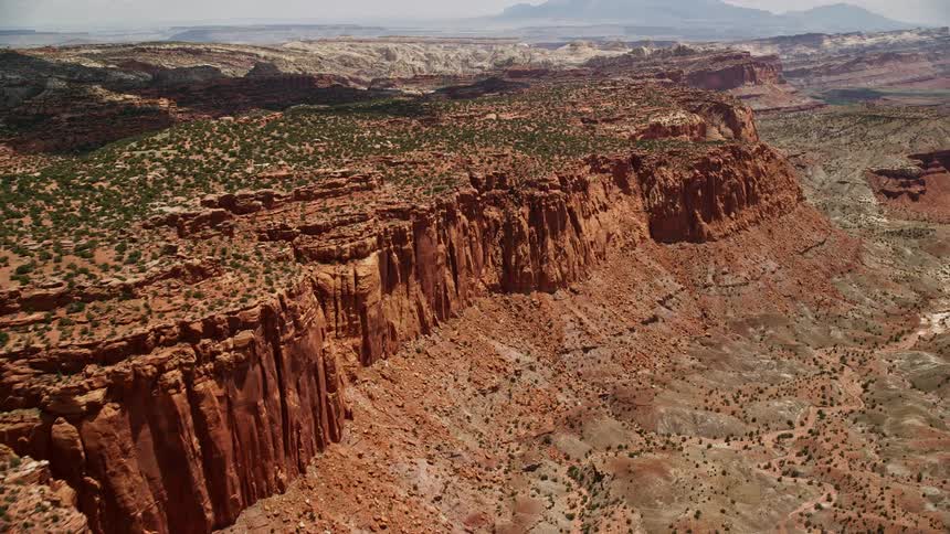 Approaching and panning across a mesa near Mummy Cliff in Capitol Reef National Park Utah showcasing the breathtaking desert landscape and famous table mountains