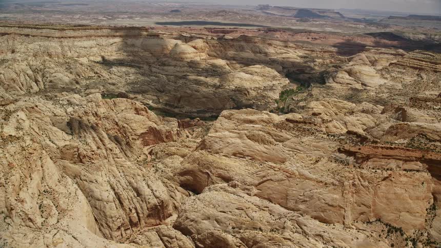 Aerial footage of a dirt road in Capitol Reef National Park Utah with a tilt to reveal stunning Waterpocket Fold rock formations