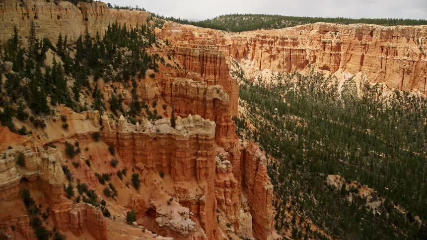 an aerial view of hoodoos and box canyons between mesas in Bryce Canyon National Park Utah with stunning rock formations and cloudy skies