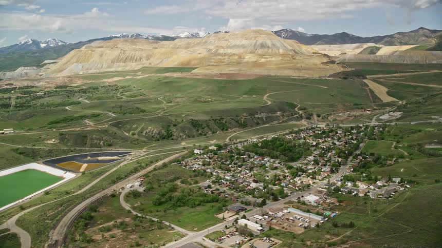 Approaching aerial view of Bingham Canyon Mine (Kennecott Copper Mine) an open-pit copper mine in Copperton Utah captured during a partly cloudy day in the Southwest United States
