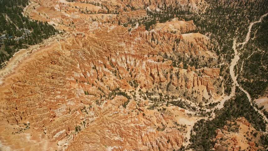 Aerial footage of circling around groups of hoodoos and buttes on a cliffside at Bryce Canyon National Park Utah showcasing the stunning natural rock formations and desert landscape