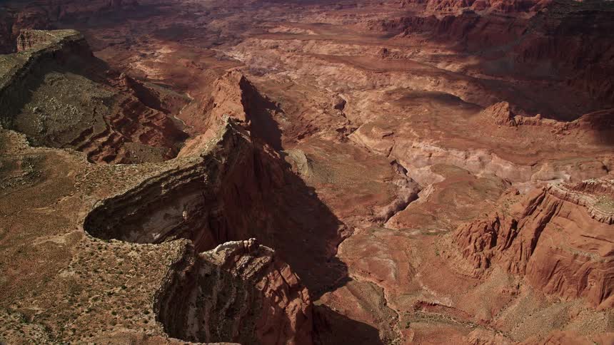 an aerial view of a tall canyon with red soil and a dry riverbed in Navajo Nation Reservation Utah showcasing the stunning beauty of the Southwest United States during summer