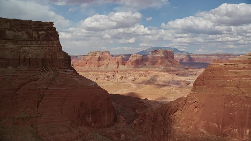Aerial footage showcasing the breathtaking landscape of the Navajo Nation Reservation in Arizona as the camera approaches and flies between large buttes