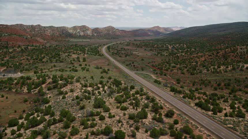 Aerial footage of cars driving on Highway 89 through the arid landscape of Glen Canyon National Recreation Area in Utah and Arizona