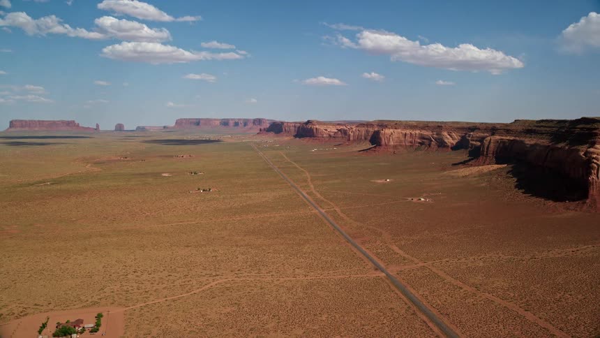 Aerial footage tilting up Oljeto Road revealing Oljeto Mesa on Navajo Nation Reservation Arizona and Utah showcasing the desert landscape and tribal lands