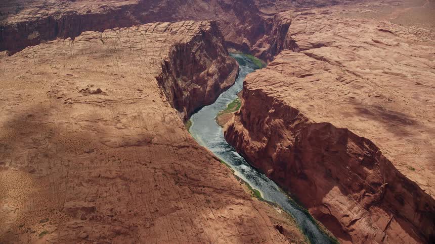Aerial view of the Colorado River flowing through a bend in the Glen Canyon Arizona showcasing the beautiful desert landscape and water body
