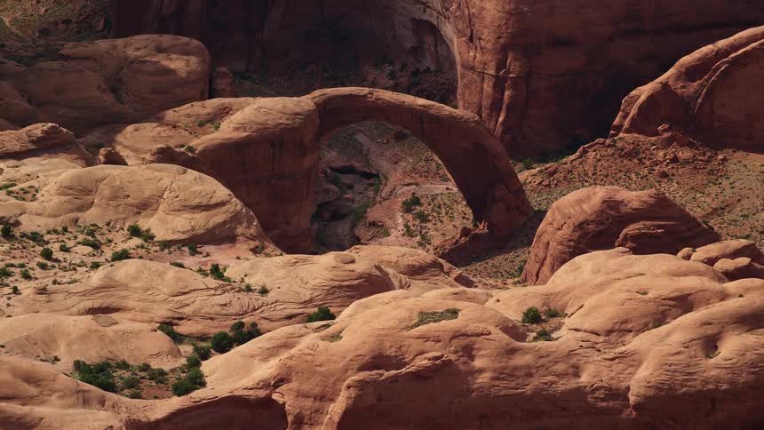 Close-up aerial view of a majestic natural stone bridge in the arid landscapes of Rainbow Bridge National Monument Utah showcasing the unique rock formations of the Southwest United States