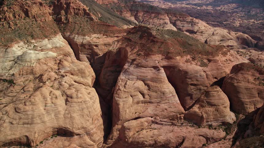 Approaching rock formations amidst partly cloudy skies at Navajo Mountain Utah during summer daytime aerials