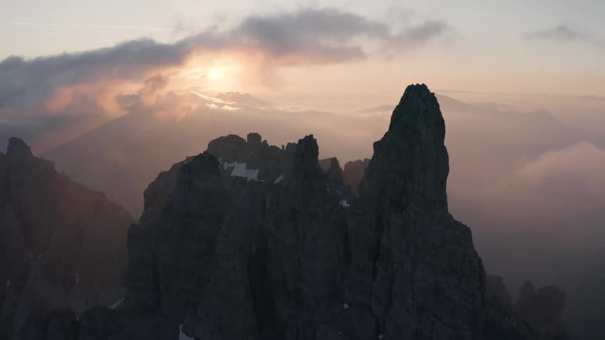 The sun is setting in the horizon above the mountains