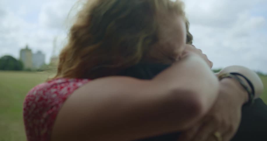 A woman smiles and hugs a man