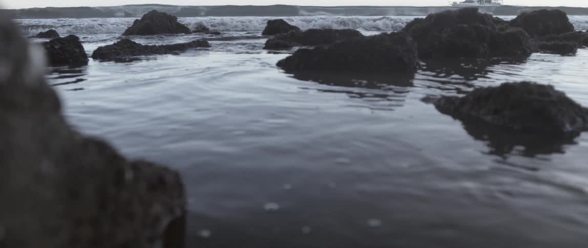 Waves slowly move towards the rocks