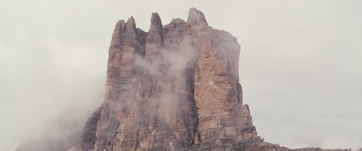 Rocky peak above the cloud level on a cloudy and misty day