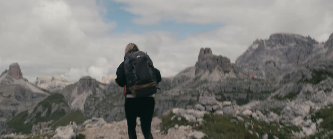 Person walks up mountain trail with backpack