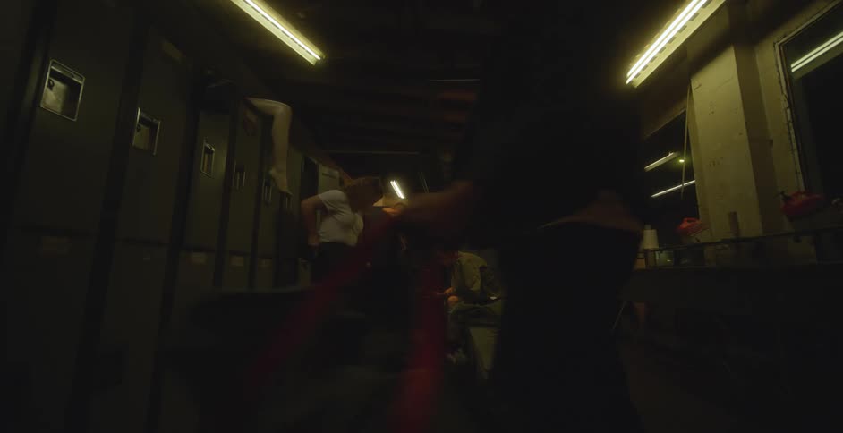 Several people finish changing in a locker room before walking out of it