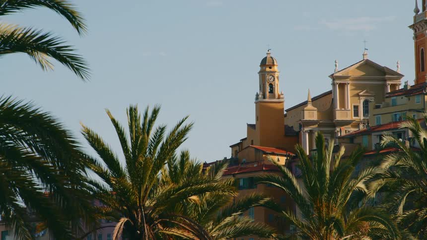 Old building structures with a clock tower church bell and palm trees