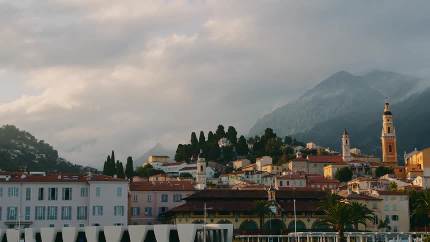 Apartment buildings at base of mountain on cloudy day