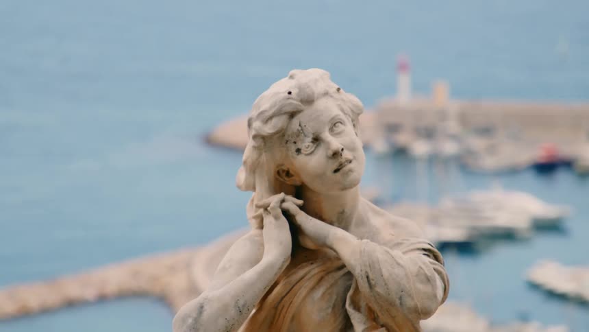 A statue of a woman is by the docks