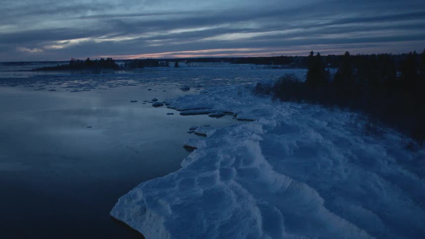 Water flows gently on a partially frozen shore