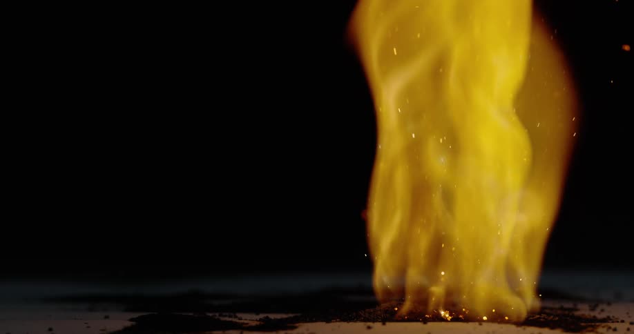 A large fire burns in a pit outside