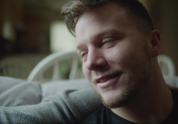 Man with a tearyeyed expression of happiness talking to someone with an emotional face