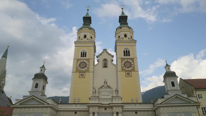 A yellow church with clock towers on the wall