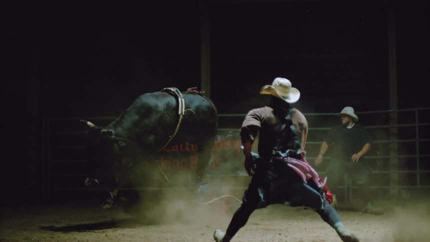 A man falls off of a bucking bull
