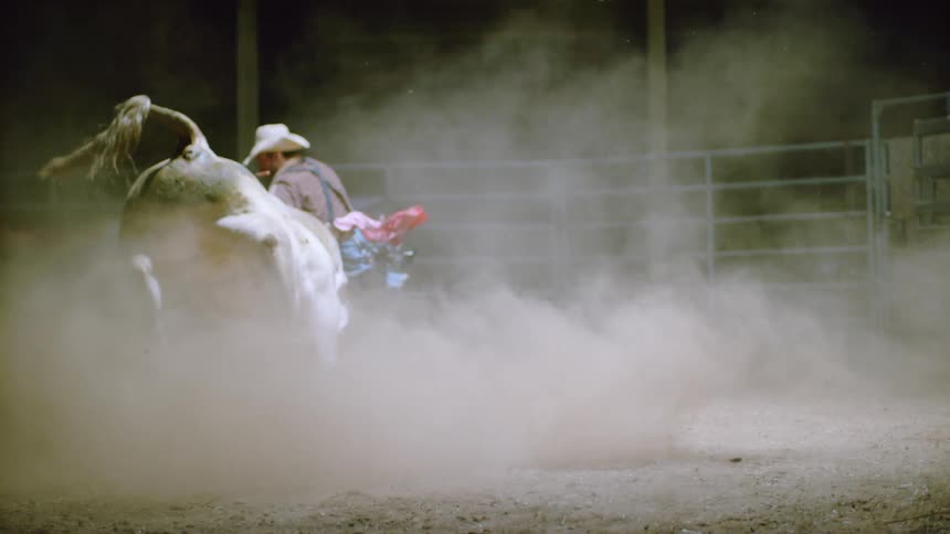 Rodeo clown trying to contain an angry bull in slow motion