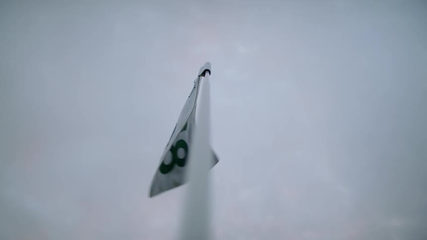 The flag on the flagstick waves in the wind on a golf course