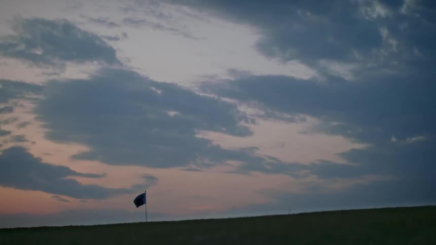 View of a small flag waving in the sunset