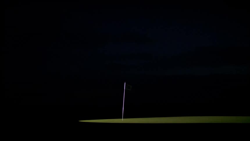 White golf flag moving in the wind during the night