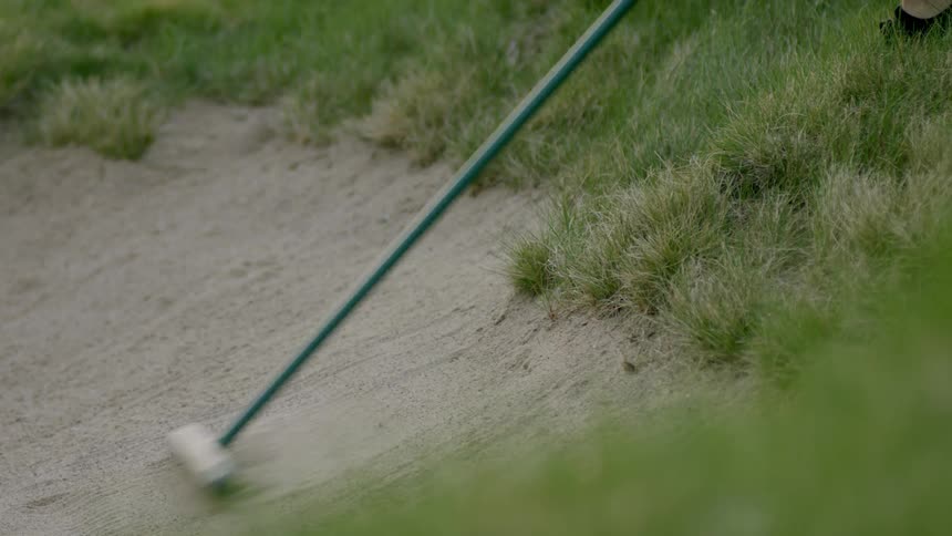 A bunker rake smooths sand and is then dropped in the grass