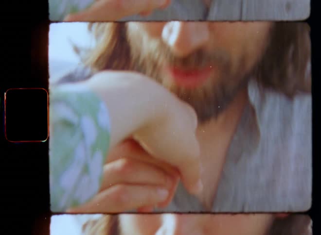 Romantic moment of a bearded man with long brown hair smiling and kissing a young lady’s hand on a Valentine’s Day date with love tenderness and happiness on Super 8mm film in a first person POV perspective