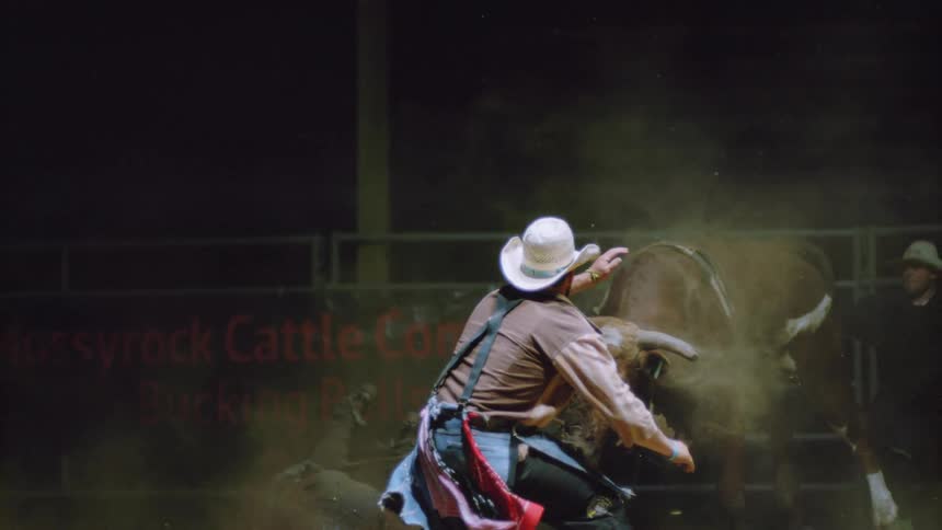 A bull is bucking as a man runs away