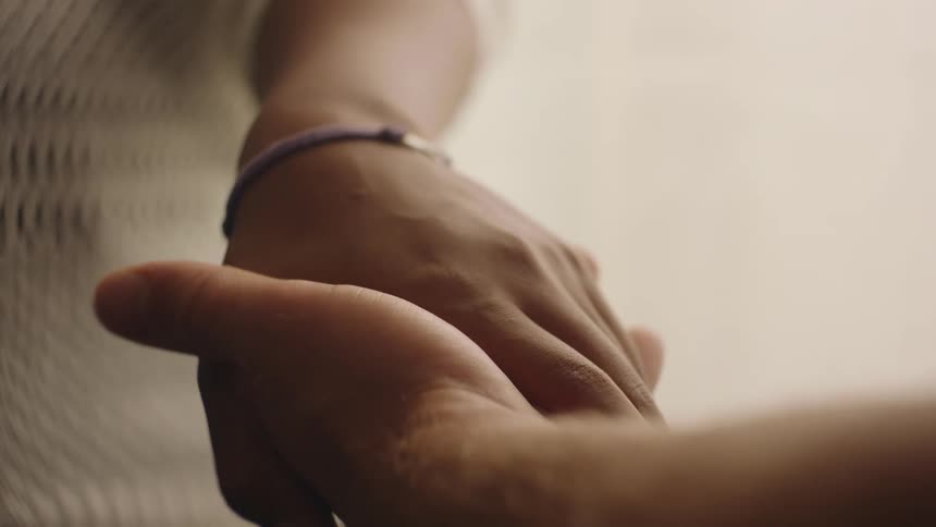Two hands embrace then release