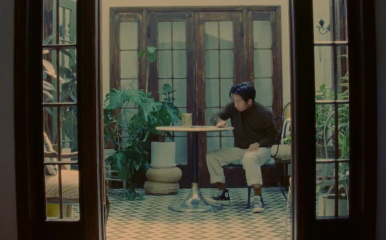 Man dances while sitting at table in home