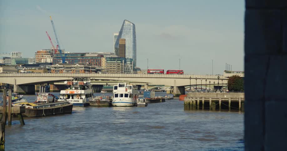 View of several boats on the open sea with a bridge in the background connecting a metropolis with vehicles and people passing by