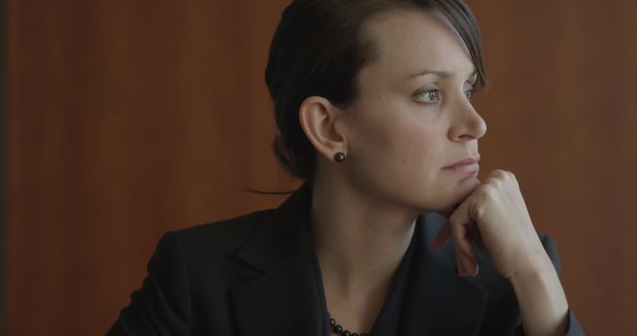 Woman sitting solemnly at a table and then getting up and leaving