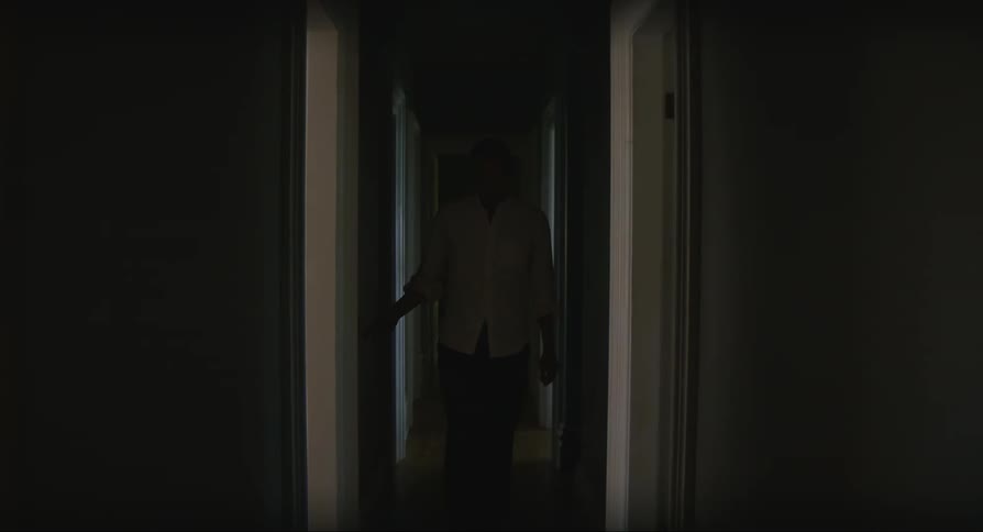 Man walks down a dimly lit hallway at home