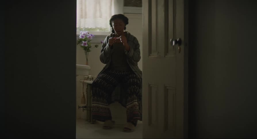 Young woman sitting looking at her pregnancy test and becoming surprised