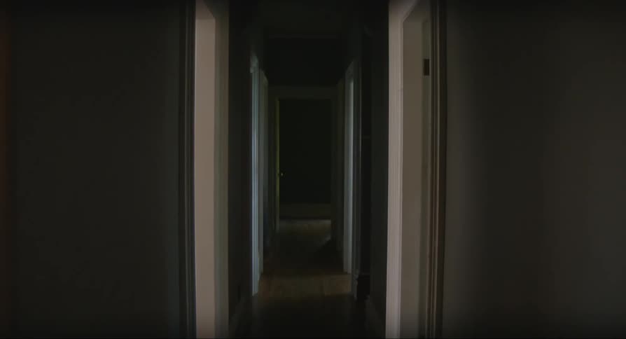 Woman wearing the robe walks down the hallway from room to room