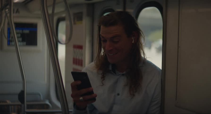 A man on public transport using his cell phone