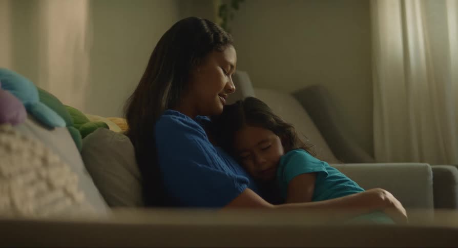 Mother sitting while her daughter sleeps in her arms