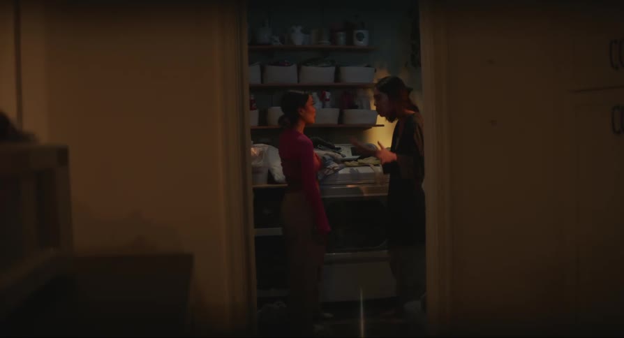 Two young women argue while standing in a room filled with baskets