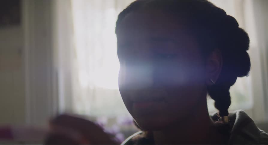 A sad young woman holds a pregnancy test