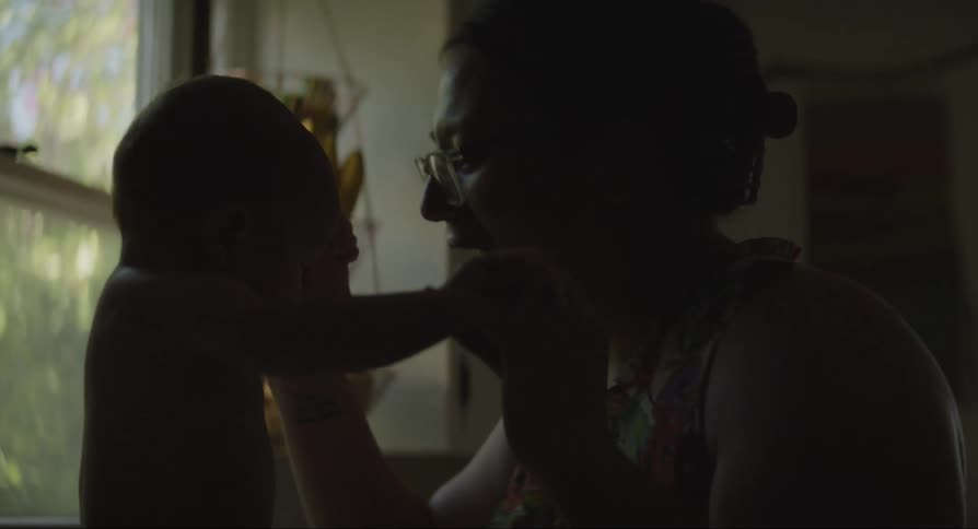 Mother playing with her baby son and hugging him