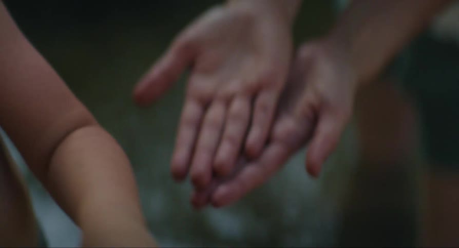 Insect in the hands of a child with another human hand preventing it from escaping