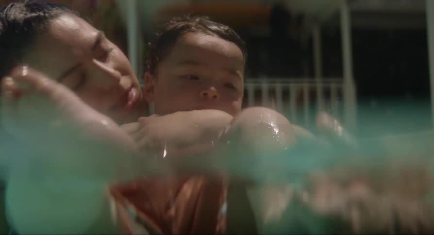 Mother in the pool playing with her baby daughter