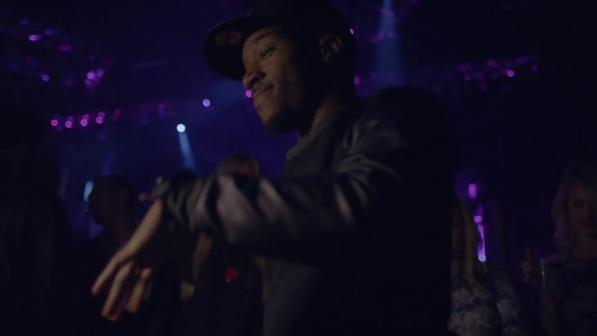 Man in a baseball cap dancing in a club